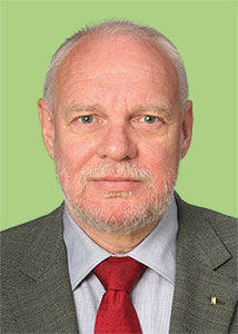 a man wearing a suit and tie smiling at the camera