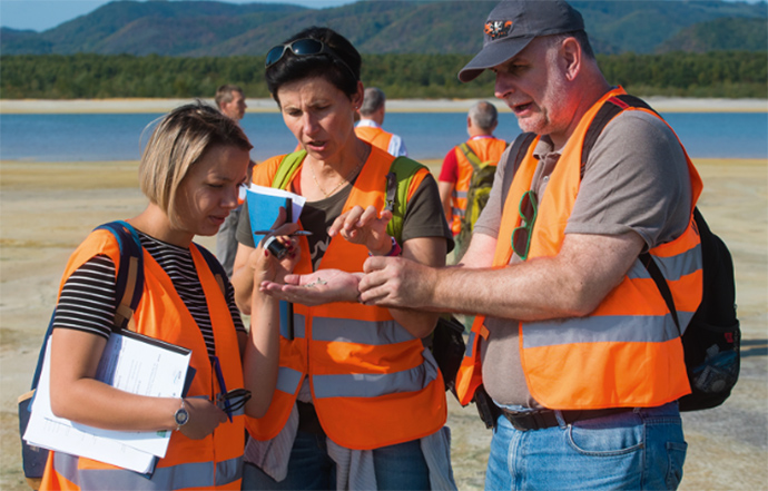 a group of people standing next to a body of water