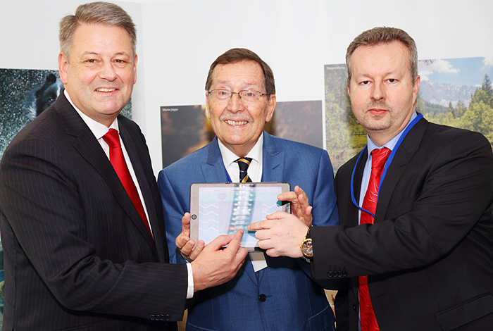 a group of people standing next to a man in a suit and tie