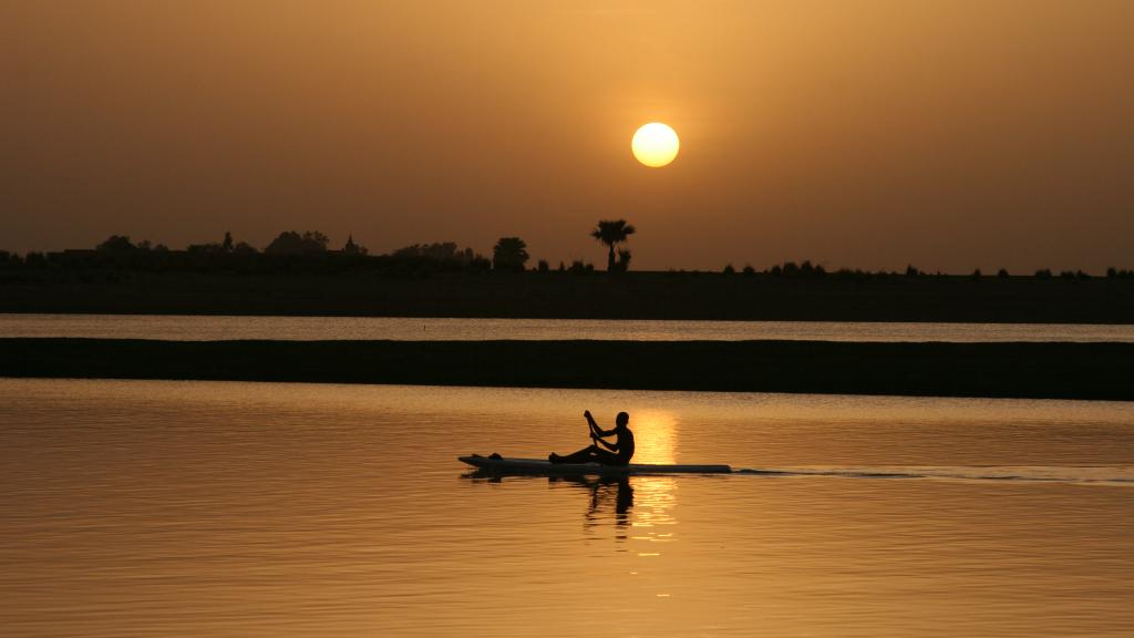 A small boat on a river during sunset