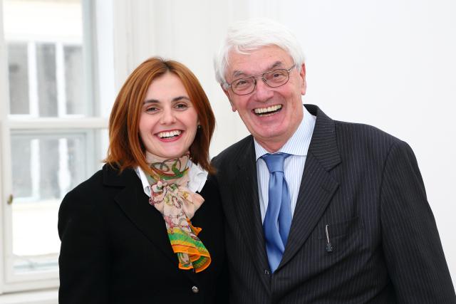 A woman and a man in suites smiling to the camera