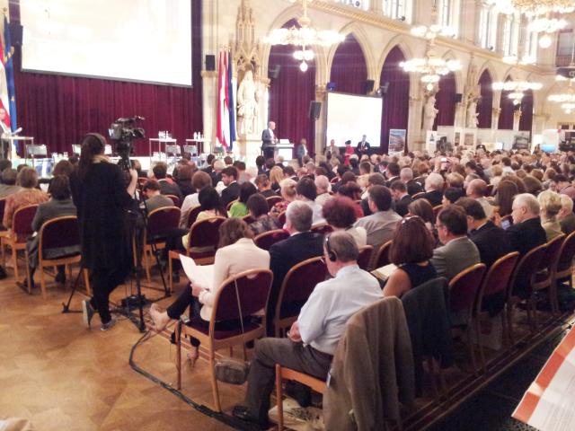 a group of people sitting at a table in front of a crowd