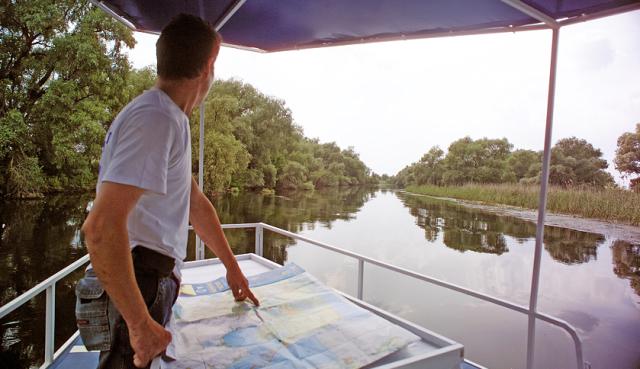 a man standing on the back of a boat