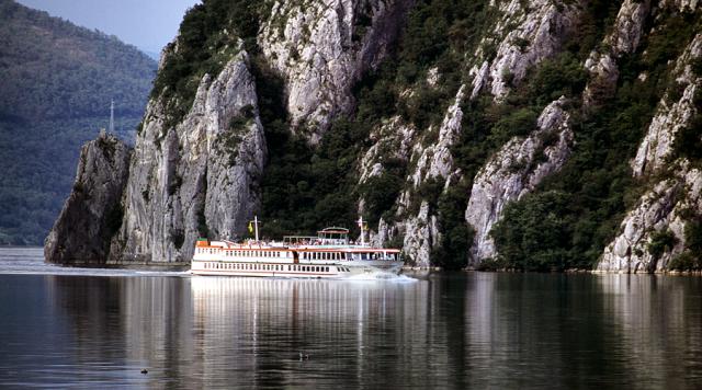 a ship on a body of water with a mountain in the background