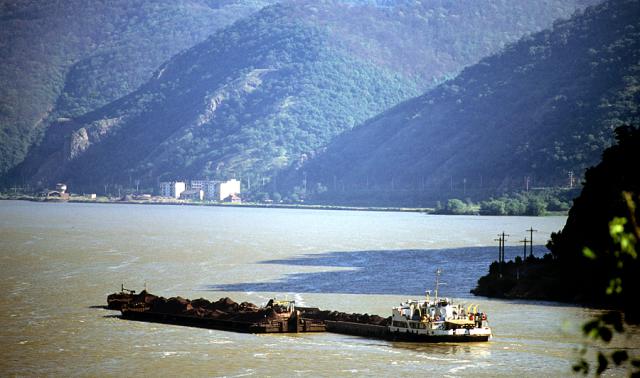 a large ship in a body of water with a mountain in the background