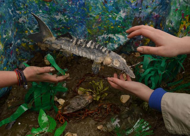 a hand holding a green reptile