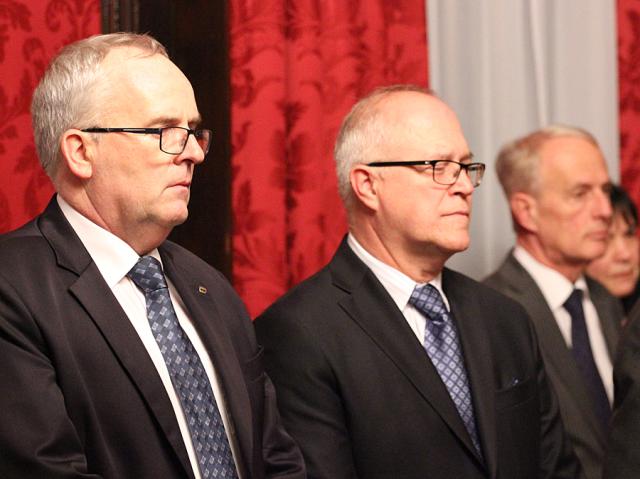 a group of people standing next to a man wearing a suit and tie